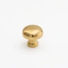 Brass mushroom-shaped cabinet knob with light surface scratches, shown against a plain white background.