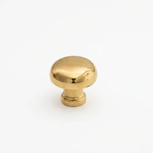 Brass mushroom-shaped cabinet knob with light surface scratches, shown against a plain white background.