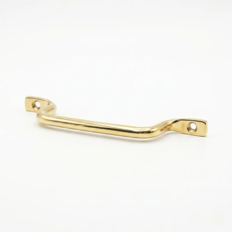 brass drawer pull handle with two screw holes and a gentle curve, shown on a white background.