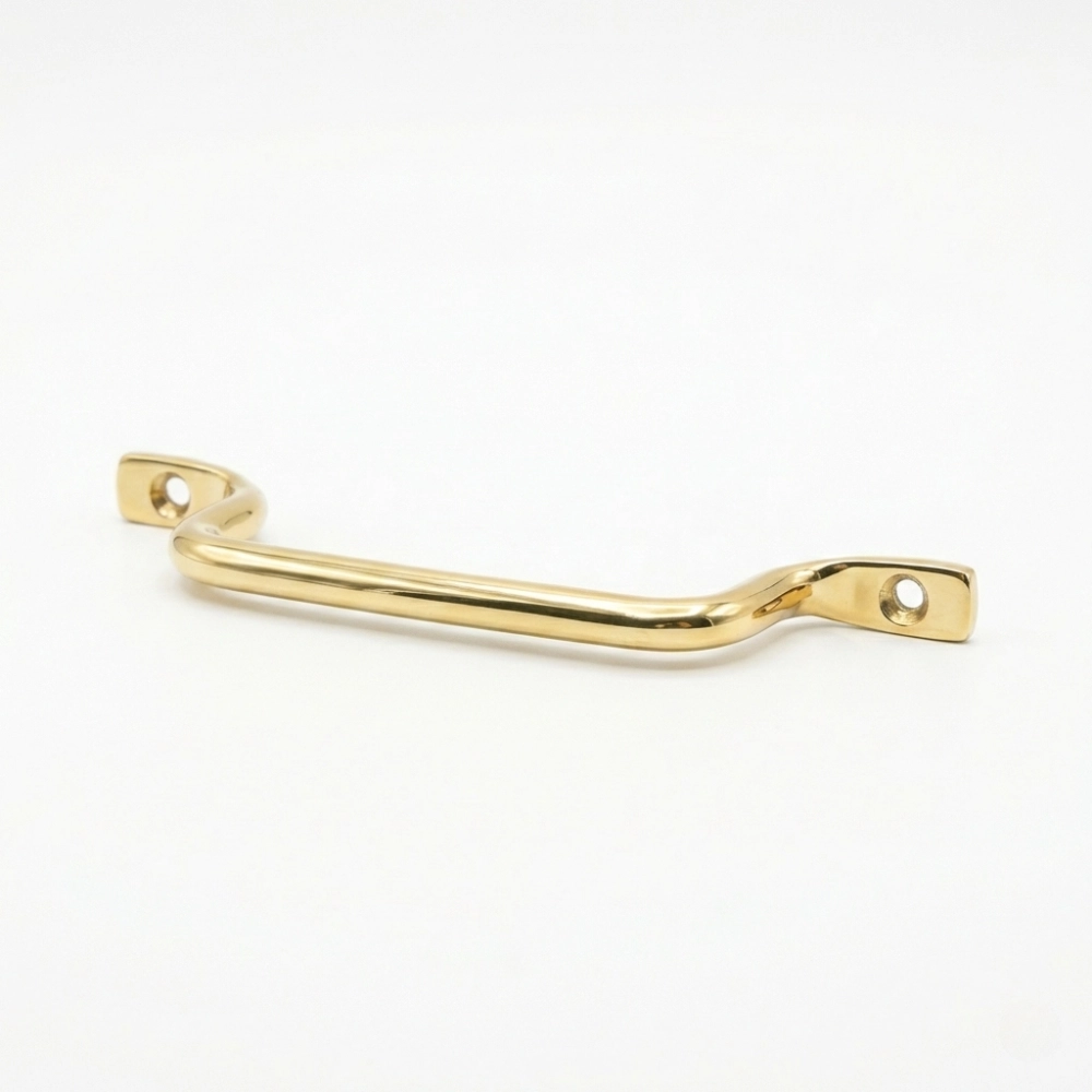 brass drawer pull handle with two screw holes and a gentle curve, shown on a white background.