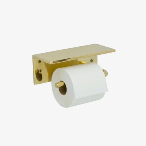 Brass wall-mounted toilet paper holder with a flat rectangular shelf and a white roll on a horizontal spindle.