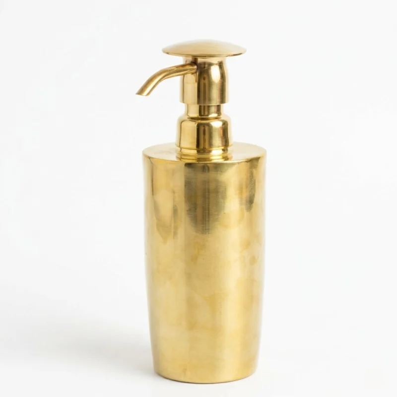 Tall brushed brass soap dispenser with a pump spout standing on a white background.